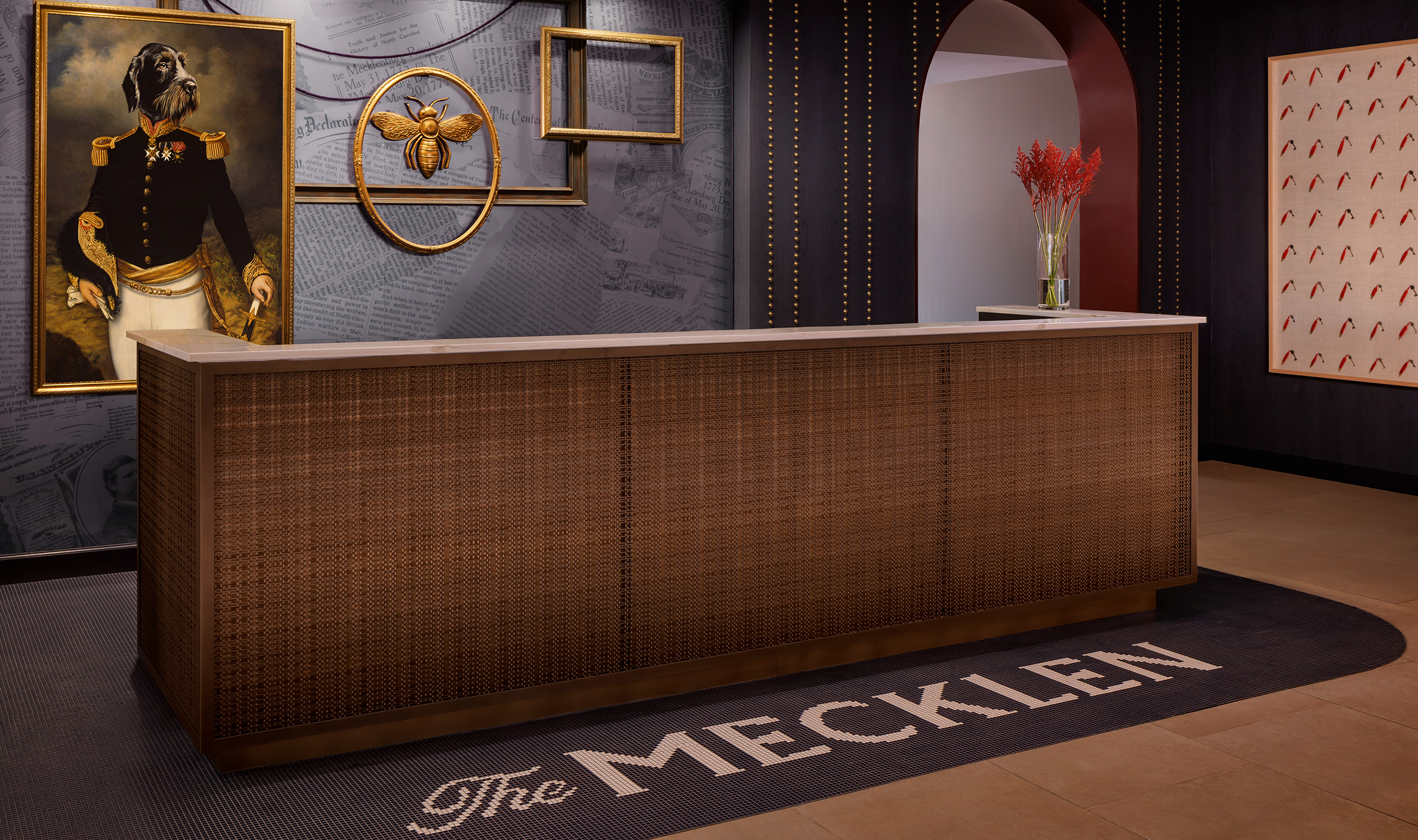 Powder coated woven wire mesh installed as cladding on a hotel front desk to provide texture and layers