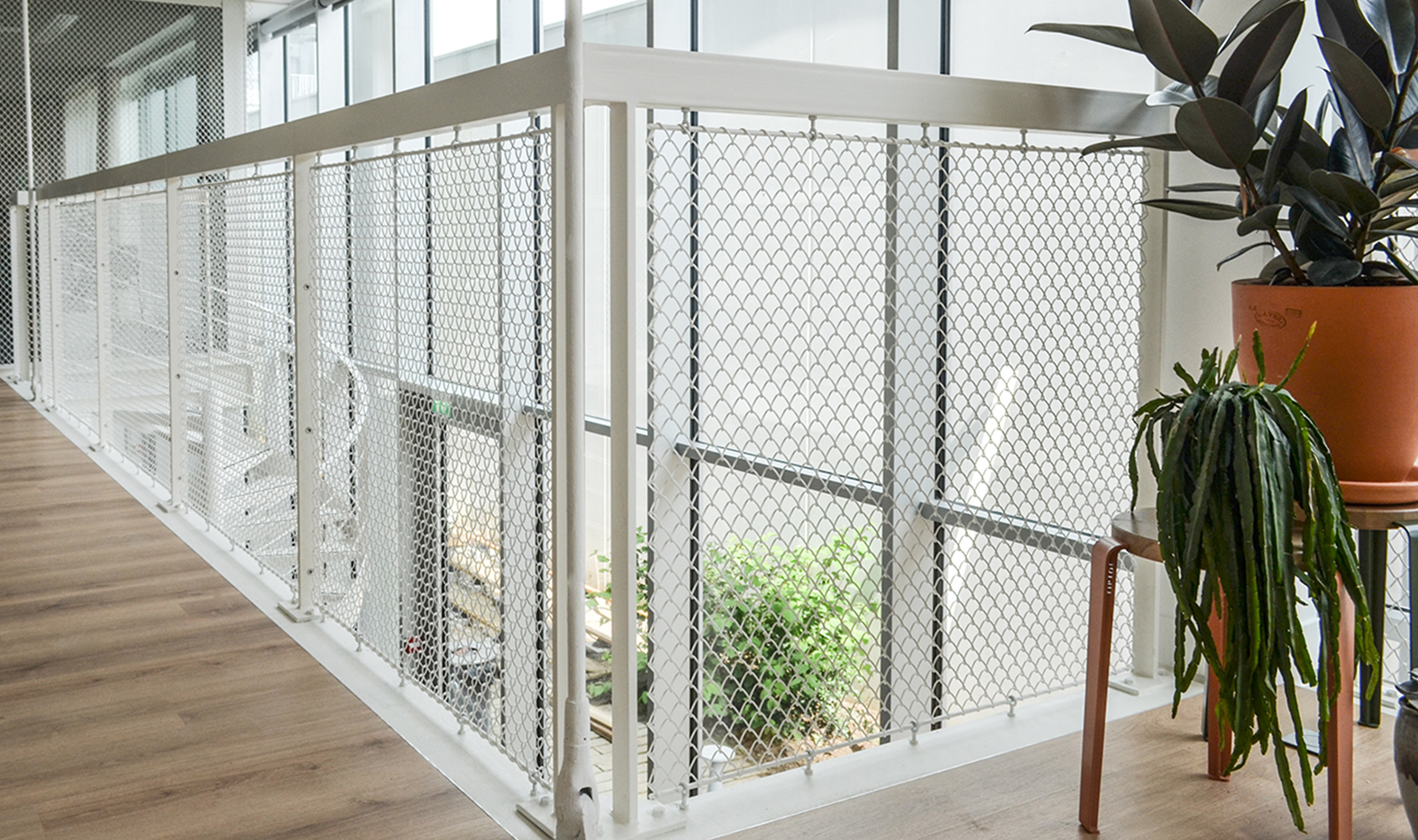 Flow flexible wire mesh installed as a space divider and railing infill Flow flexible wire mesh installed as a space divider and railing infill