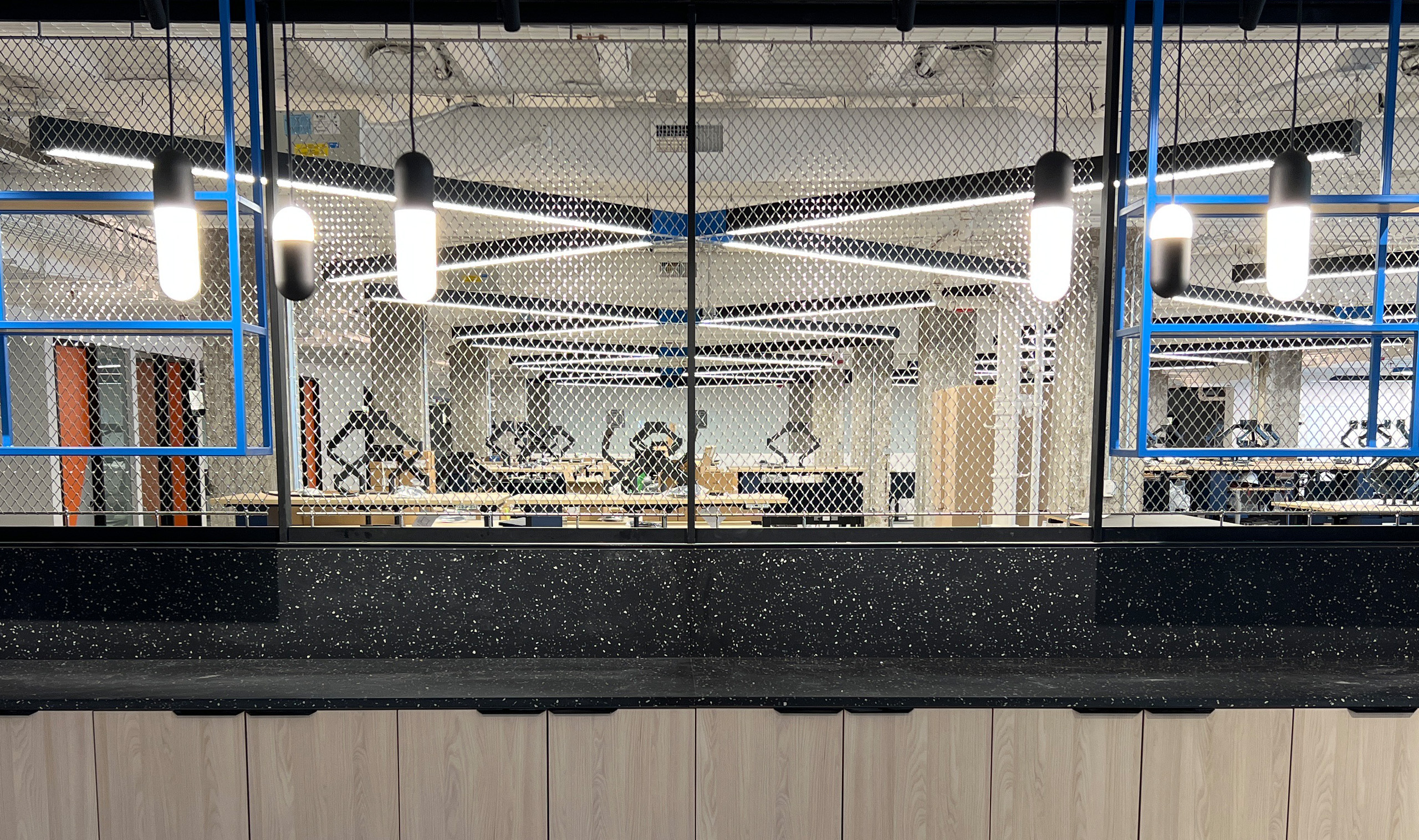 Flow flexible wire mesh installed as a space divider in a commercial space Flow flexible wire mesh installed as a space divider in a commercial space