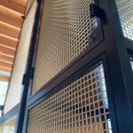 Close-up of L-441 architectural wire mesh woven in bare bronze at Ace Porter bar