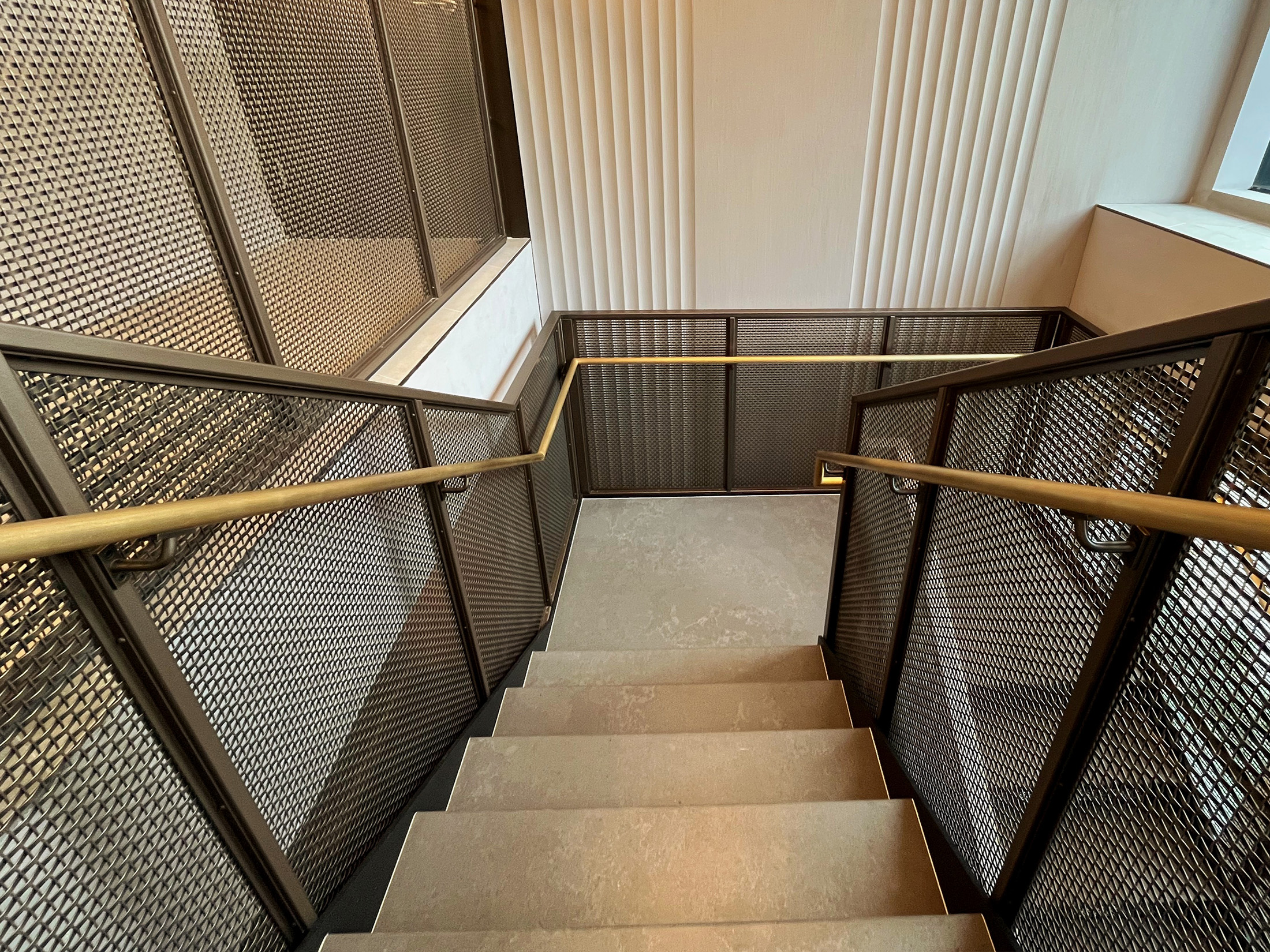 This New York project highlights the beauty and functionality of woven wire mesh in stairwell handrails. This design offers durability, light flow, and a clean aesthetic for upscale commercial spaces.