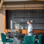 Decorative woven wire mesh installed in corporate interior design as a gantry over a bar