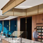 Decorative woven wire mesh installed in corporate interior design as a gantry over a bar