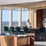 Decorative woven wire mesh installed in corporate interior design as a gantry over a bar