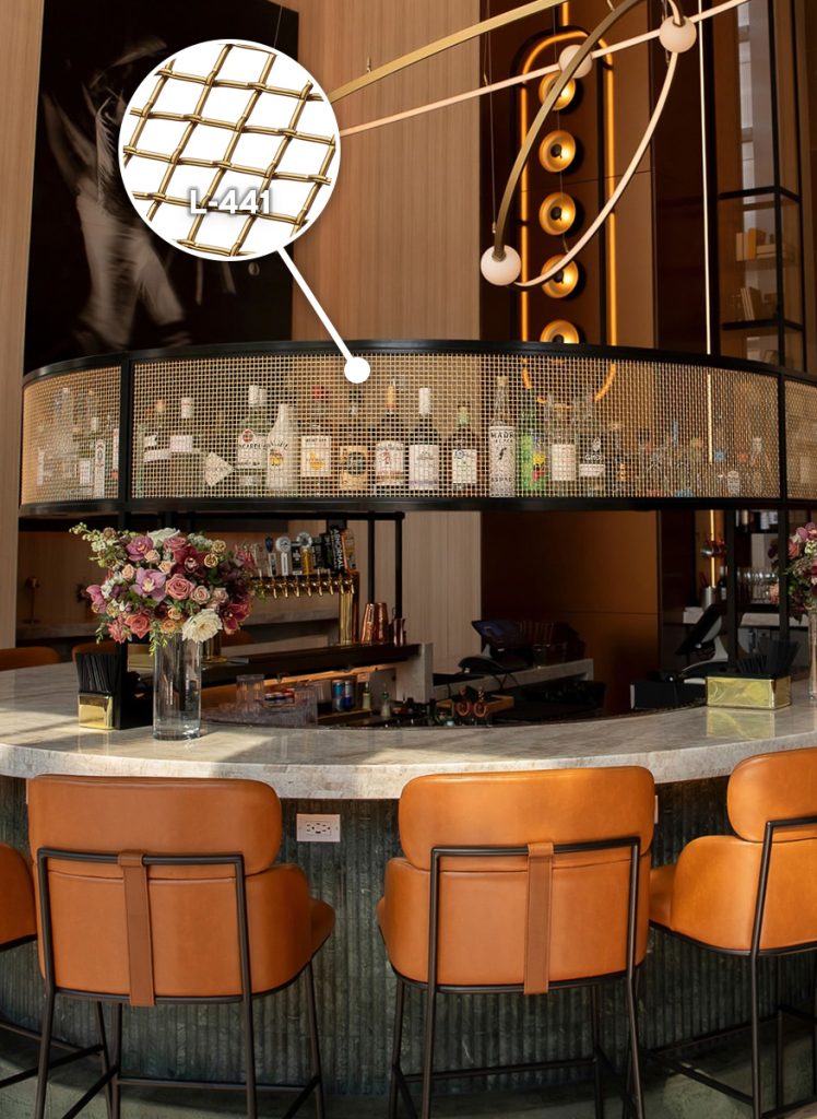 Bronze woven wire mesh installed as an overhead gantry cabinet at a hotel lobby bar Bronze woven wire mesh installed as an overhead gantry cabinet at a hotel lobby bar