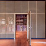 A contemporary wine tasting space features M22-83 brass woven wire mesh as a space divider for a tasting room.