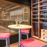 A contemporary wine tasting space features M22-83 brass woven wire mesh as a space divider for a tasting room.
